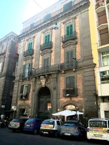 a building with cars parked in front of it at QUEEN MEDINA Centro Storico in Naples
