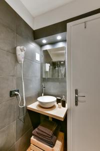 ein Bad mit einem Waschbecken und einem Spiegel in der Unterkunft BRUNA HOLIDAYS HOUSE in Burano