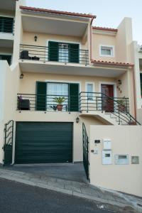 uma casa com duas portas de garagem em frente em ZiZis Place em Santa Cruz - Madeira