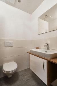 a white bathroom with a toilet and a sink at Apart Life in Sölden