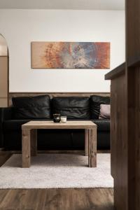 a coffee table in a living room with a black couch at Apart Life in Sölden