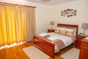 a bedroom with a bed and yellow curtains at ZiZis Place in Santa Cruz