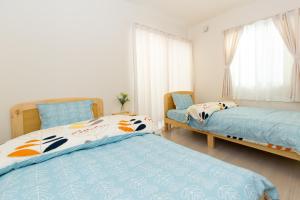 1 dormitorio con 2 camas y 2 sillas en 足跡 ASHIATO en Tokio