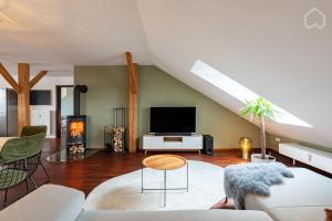 a living room with a couch and a tv at 110qm Countryside Loft in Neufahrn in Niederbayern