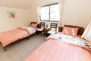 1 dormitorio con 2 camas y ventana en 足跡 ASHIATO en Tokio