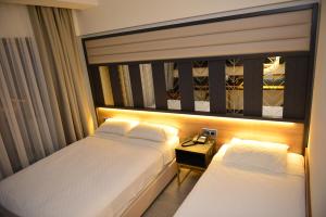 a hotel room with two beds and a night stand at Oasis Hotel in Marmaris +38 photos