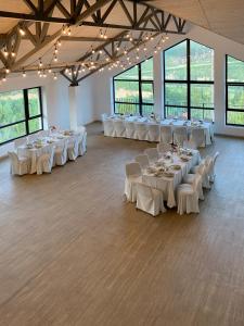 a banquet hall with white tables and white chairs at Карпатський Затишок in Slavske +70 photos