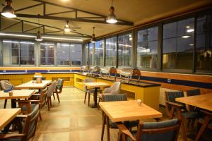 a restaurant with wooden tables and chairs and windows at Oasis Hotel in Marmaris