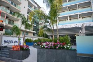 a hotel with flowers in front of a building at Oasis Hotel in Marmaris