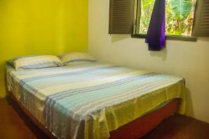 1 dormitorio con 1 cama en una habitación amarilla en Macondo Hostel, en Morro de São Paulo