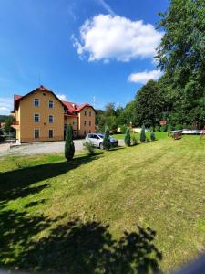 a large grassy yard with a house in the background at Ośrodek Wypoczynkowy Buenos Aires in Kudowa-Zdrój