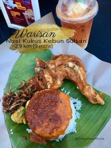 a plate of food with meat on a banana leaf at Ziehass Homestay D'Perdana Apartment in Kota Bharu