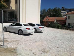 dois carros brancos estacionados ao lado de um edifício em family hotel - City hotel yambol em Yambol