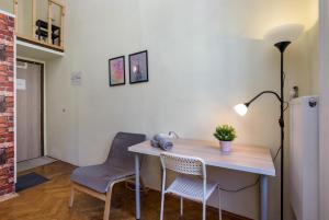 escritorio con 2 sillas y lámpara en la habitación en Budapest Three Cats Hostel, en Budapest