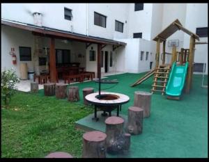 a playground with a table and a slide at Conforto em Campos in Campos do Jordão