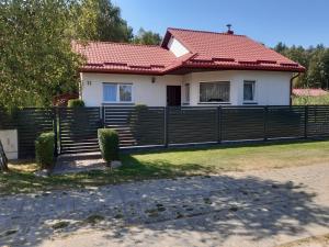 a house with a fence in front of it at Dom Bursztyn in Rusinowo