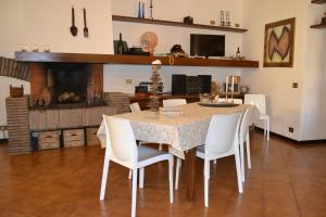 トゥスカーニアにあるcase vacanza Il Castelloのダイニングルーム(テーブル、白い椅子付)