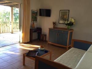 a living room with a couch and a tv at Villa Les Hameaux Di Santa Giulia in Porto-Vecchio