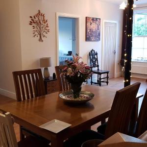 a dining room table with a vase of flowers on it at Saracens House in Preesall