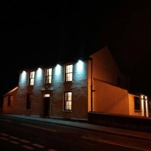 a building with lights on the side of it at night at Saracens House in Preesall