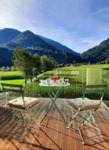 einen Tisch und Stühle auf einer Terrasse mit Bergen im Hintergrund in der Unterkunft MANTANA - Apartments in St. Lorenzen