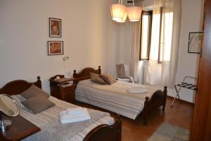 トゥスカーニアにあるcase vacanza Il Castelloのベッドルーム1室(ベッド2台、テーブル、窓付)
