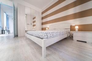 1 dormitorio con cama y pared a rayas en Gli appartamenti della Fra, en Lavagna