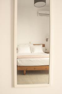 a bedroom with a bed through a mirror at New and Airy Apartment few steps from the beach in Sougia