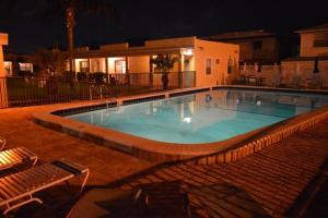 a large swimming pool at night with two lounge chairs at The Monterey Beach Resort in St Pete Beach