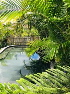 een zwembad in een tuin met palmbomen bij Segara Healing Villa in Kintamani