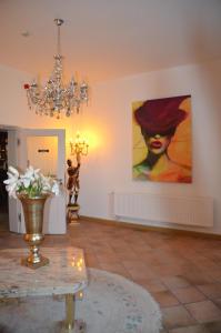 a living room with a painting on the wall and a chandelier at Hotel zur Köppe in Bad Klosterlausnitz