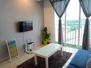 ein Wohnzimmer mit einem weißen Tisch und einem TV in der Unterkunft Homi Homestay Menara U2 in Shah Alam