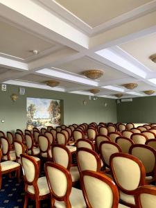 Rezydencja Pod Zegarem في تريبينا: غرفة فارغة فيها صفوف من الكراسي والطاولات