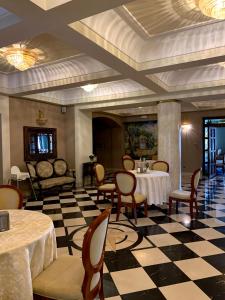 restauracja ze stołami i krzesłami oraz podłogą wyłożoną szachownicą w obiekcie Rezydencja Pod Zegarem w mieście Trzebinia