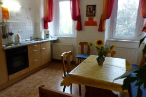 a kitchen with a table with a vase of flowers on it at Pension Schreckhof in Mosbach