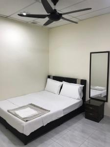 een slaapkamer met een bed en een plafondventilator bij Ilham Bonda 2 Homestay in Cukai