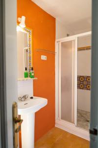 uma casa de banho laranja com um lavatório e um chuveiro em Finca el Moro - Casita del Cerro em Aracena