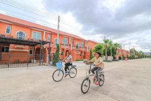 twee vrouwen die fietsen in een straat bij Munlihouse Cha-Am Hua-Hin Beach in Cha Am