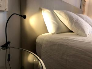 a bedroom with a bed with a white pillow and a lamp at Diana 16 in Denia