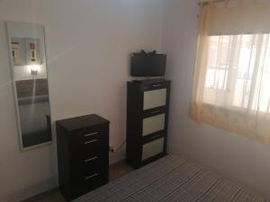 1 dormitorio con TV y vestidor con cama en Vandaele Home en Corralejo