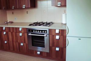 a kitchen with a stove and a refrigerator at Dom pod Górami in Mirsk