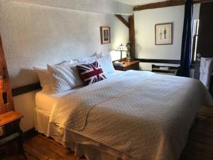 a bedroom with a large white bed with two pillows at The Olde Angel Inn in Niagara-on-the-Lake