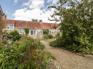 una casa antigua con un jardín delante de ella en Yeoman Cottage, en Crewkerne