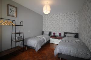 1 dormitorio con 2 camas y una estantería con velas en Les Lauriers de la route des vins, en Orschwihr