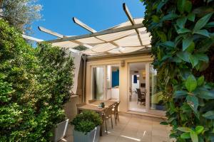 eine Terrasse mit einer Pergola, einem Tisch und Stühlen in der Unterkunft Hotel La Villa Del Mare in Cagliari