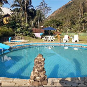 una piscina con una pila de rocas en el medio en Pousada Chácara do Rio, en Lumiar