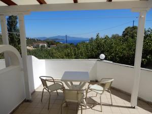 una mesa y sillas en un balcón con vistas en Villa Teozenia, en Achladies