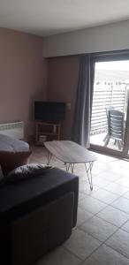 uma sala de estar com um sofá e uma mesa de centro em Appartement à Bredene au rez-de-chaussée em Bredene