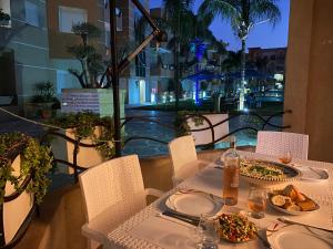 einen Tisch mit einem Teller Essen auf dem Balkon in der Unterkunft Residence Les Dunes POOL VIEW 3 Bedroom Apartment in Sousse