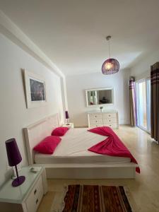 a bedroom with a large bed with red pillows at Residence Les Dunes POOL VIEW 3 Bedroom Apartment in Sousse